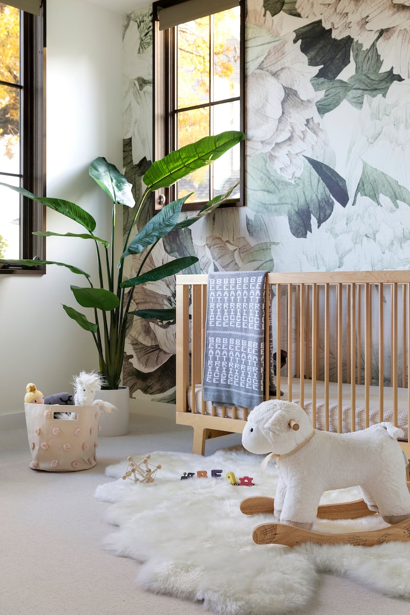  A nursery featuring floral wallpaper, modern furniture and Marvin Ultimate casement windows.