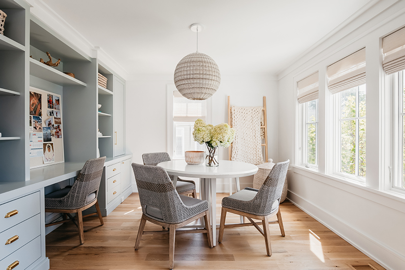 A dining room with built-in desk in Liz Joy’s home, featuring Marvin Elevate casement windows.