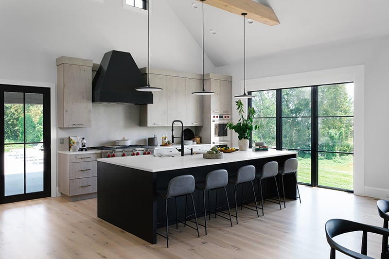 The kitchen in a modern farmhouse in Norwalk, Connecticut, featuring Marvin designer black windows and doors.