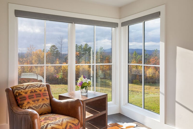 A sitting area in The Middletown Ridge House with a view of nature outside Marvin windows.