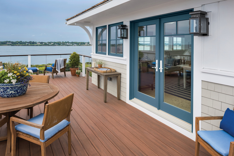 A resort style deck featuring Marvin Signature Ultimate Sliding French Doors and Ultimate casement windows.