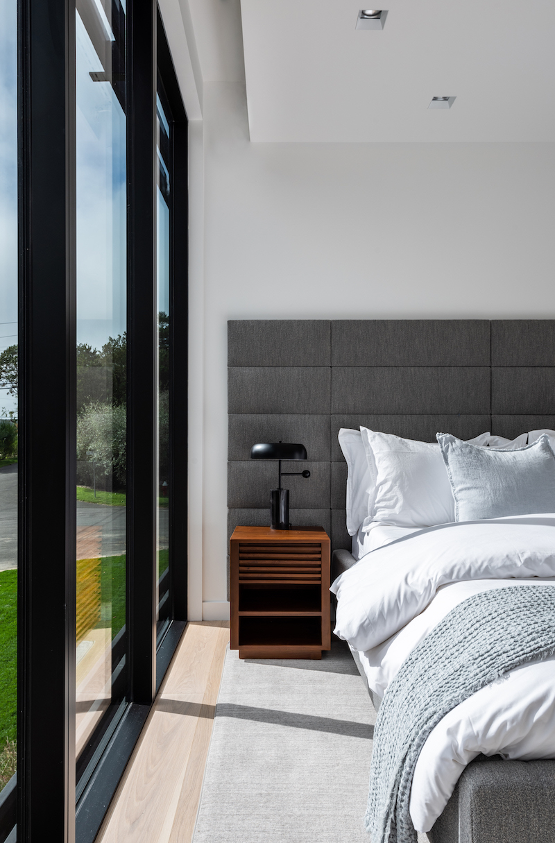 A modern bedroom in Sag Harbor, New York, designed by THE UP STUDIO, featuring Marvin Modern windows and doors.