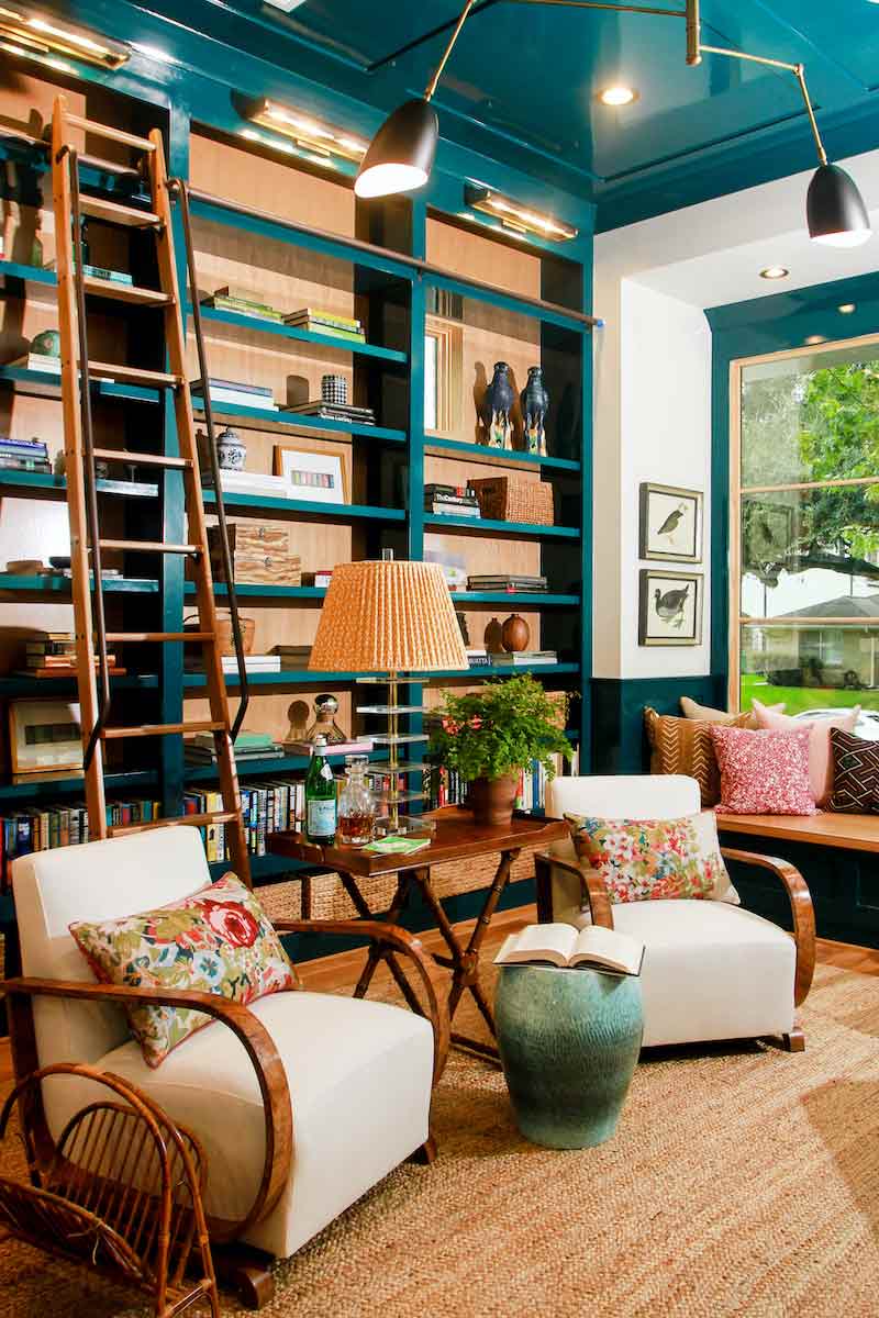 A library or reading room featuring blue built-ins and Marvin windows.