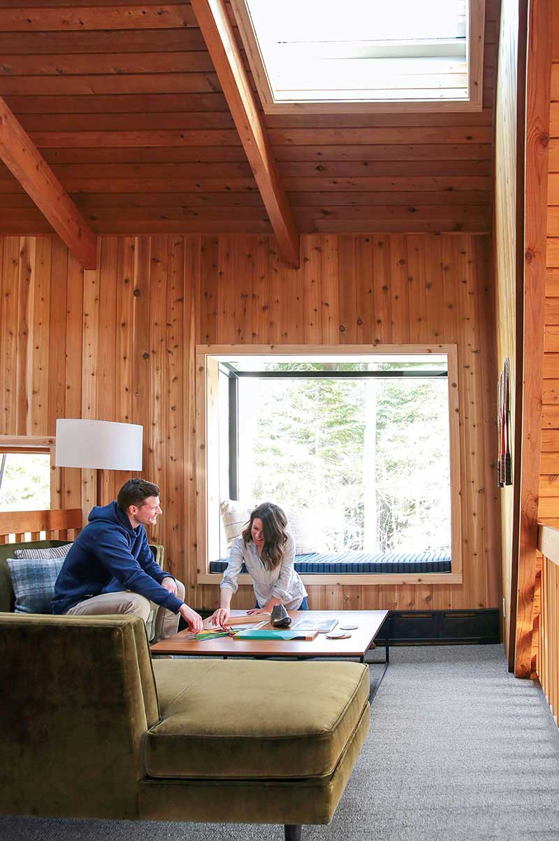 Melissa Coleman and her husband in the loft of The Minne Stuga, their A-frame cabin, featuring Marvin Awaken Skylight and Marvin Skycove.
