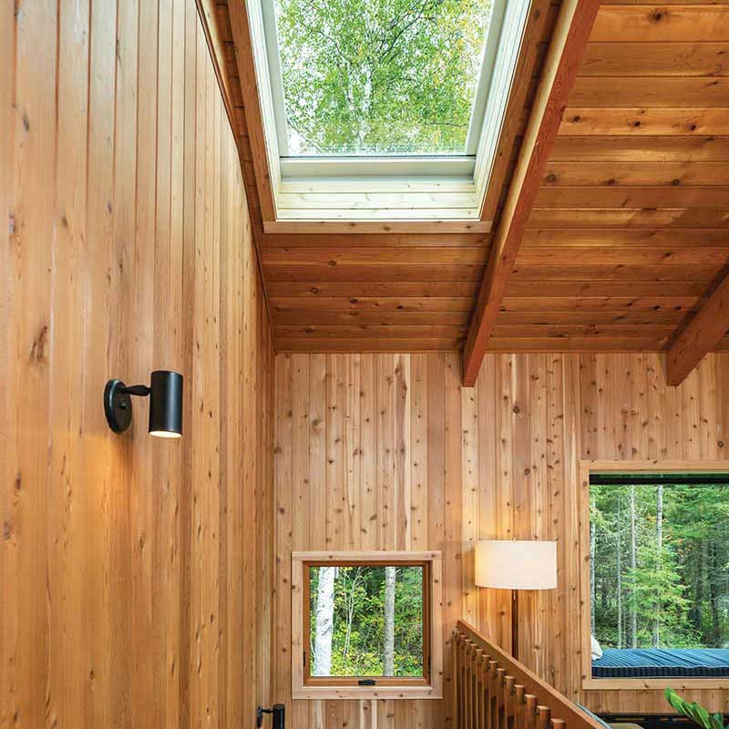 An A-frame cabin in Northern Minnesota, featuring cedar-clad walls, a Marvin Awaken Skylight, Marvin Skycove and an Ultimate Awning window.