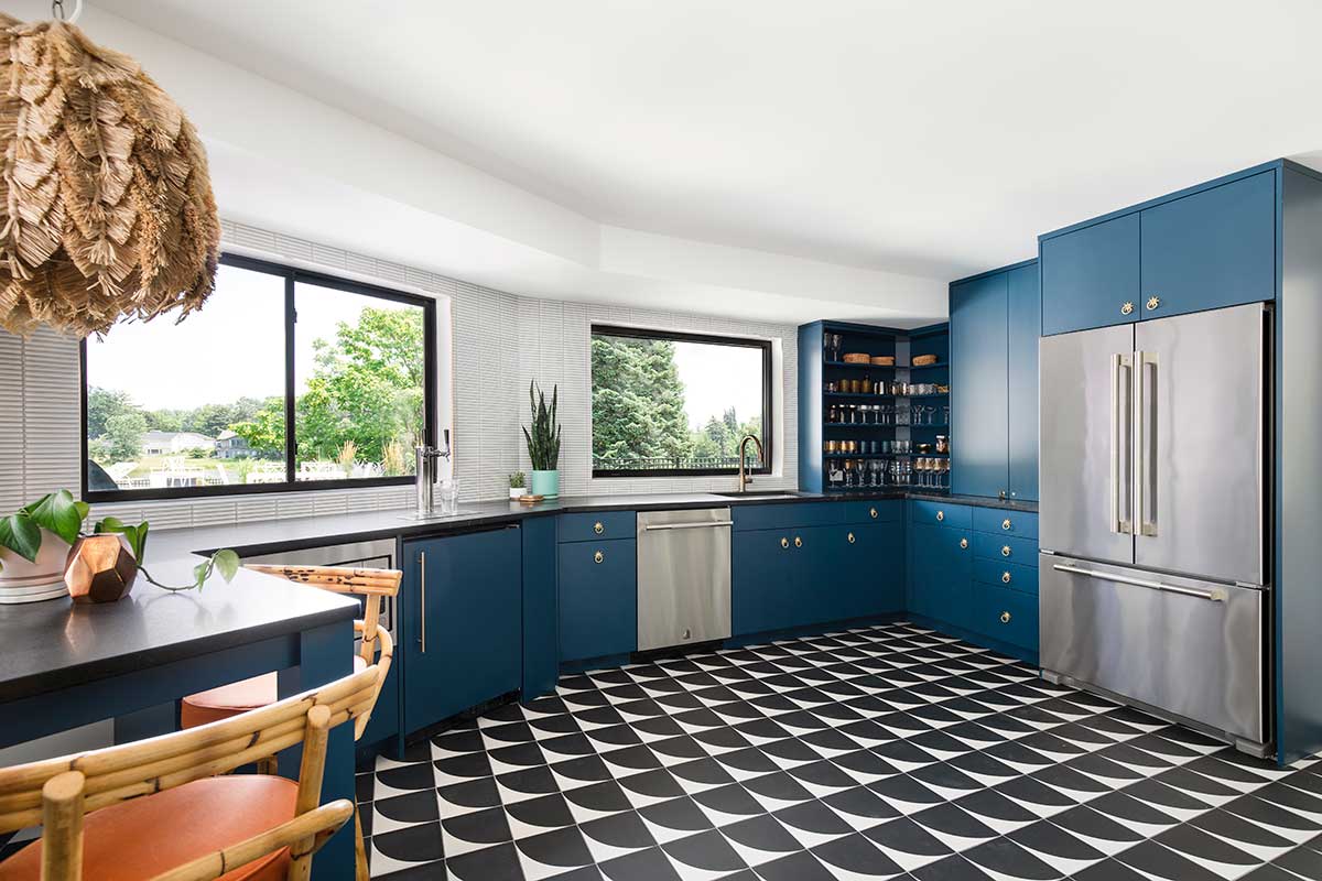 A mid-century style bar area with black and white tile, navy blue cabinets and Marvin Essential windows.
