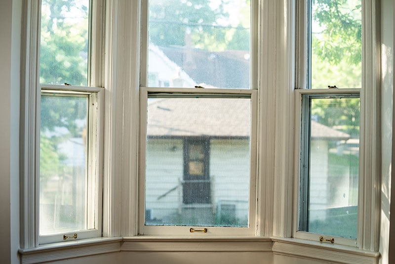 Windows with foggy glass in the upper story of a home.