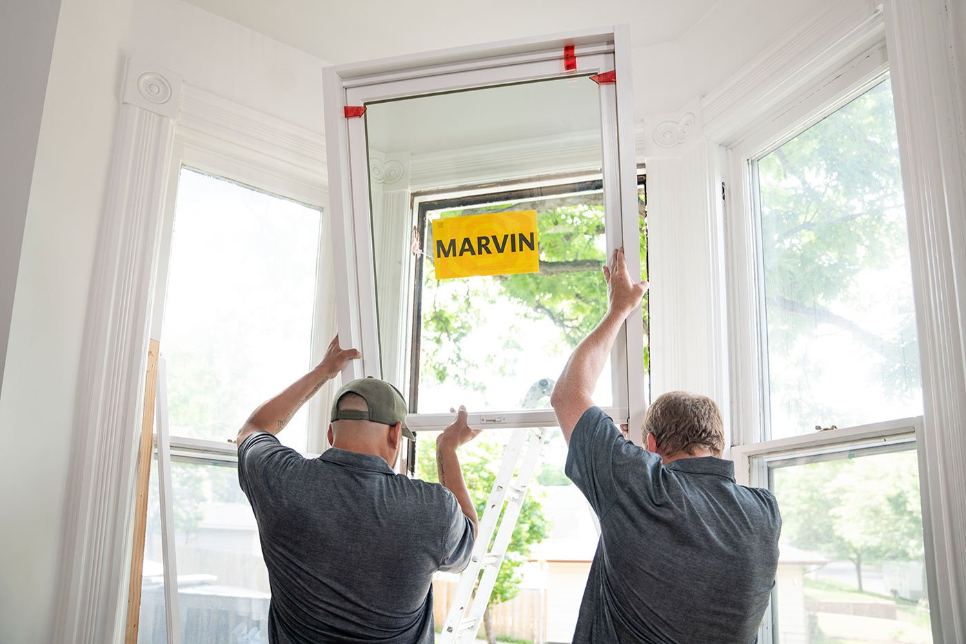 Window installers putting in a new Marvin double hung window.
