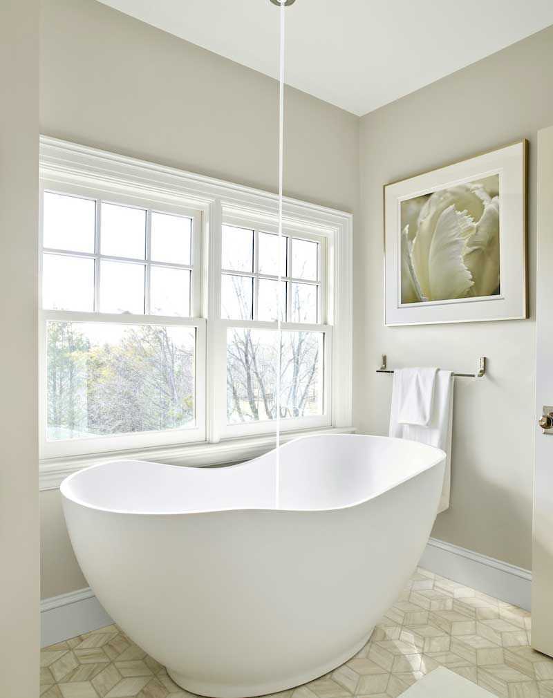 A bathroom in the This Old House Cape Ann home featuring a large soaker tub with faucet that flows from the ceiling.