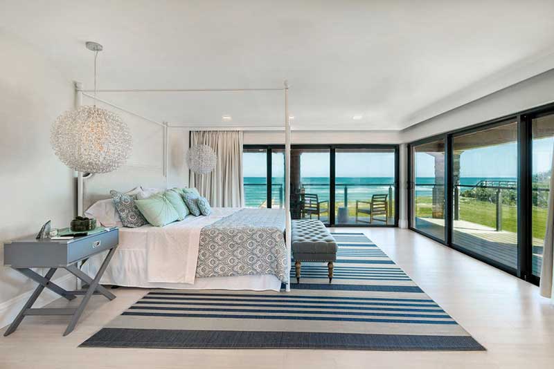 A bedroom in the coastal southeast featuring Marvin Coastline Multi-Slide doors.