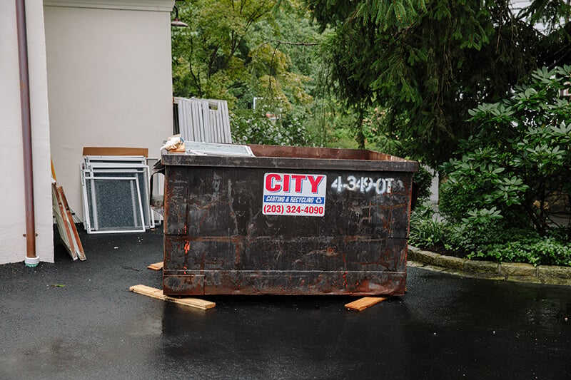 Dumpster in driveway of home in preparation for window replacement.