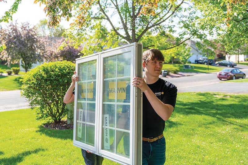A Marvin certified installing contractors carrying a replacement window.