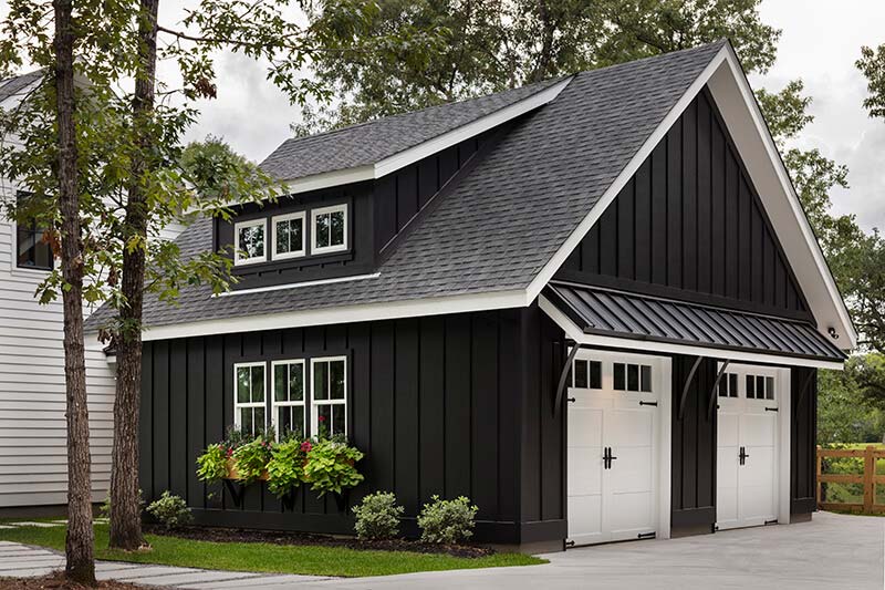 Exterior shot of a black two-car garage with white doors and windows.
