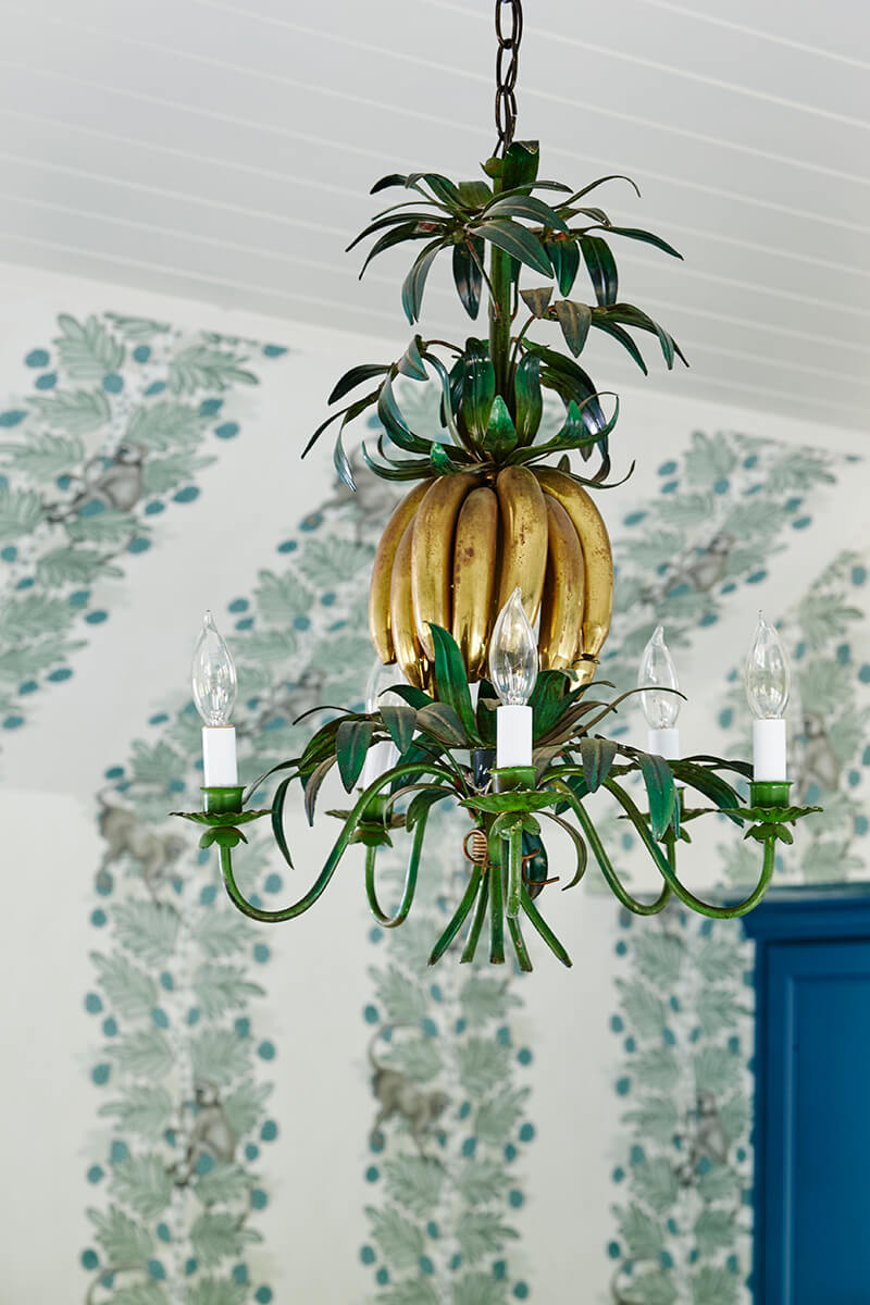 Unique chandelier in room with wallpaper walls