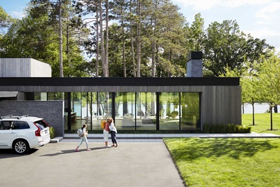 Two people hugging outside a modern home