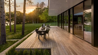 An outside view of a Marvin Modern Multi slide door on a deck with a dining table
