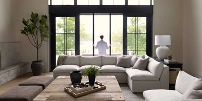 A person opening up an Ultimate Sliding French Door in a living room with a white couch