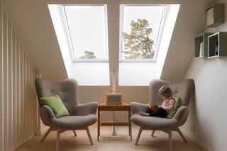 Girl sitting on a chair in a reading nook in the daytime with Marvin Awaken Skylights
