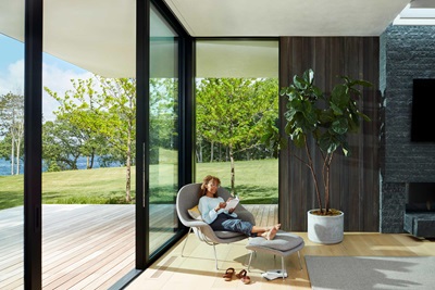 A person sitting in a char in the living with a Marvin Modern Multi Slide door
