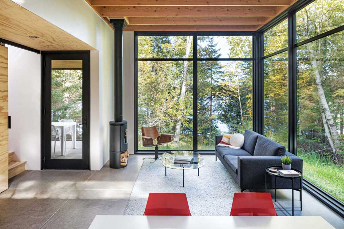Floor-to-ceiling Marvin windows (framed with sustainably sourced pine and aluminum), a wood-burning stove, and exposed fir support beams welcome views of nature and wildlife into the main living space.