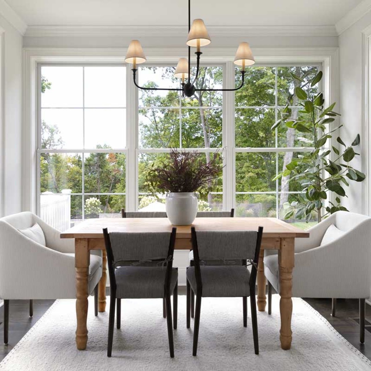 Dining room with wood table surrounded by double hung windows