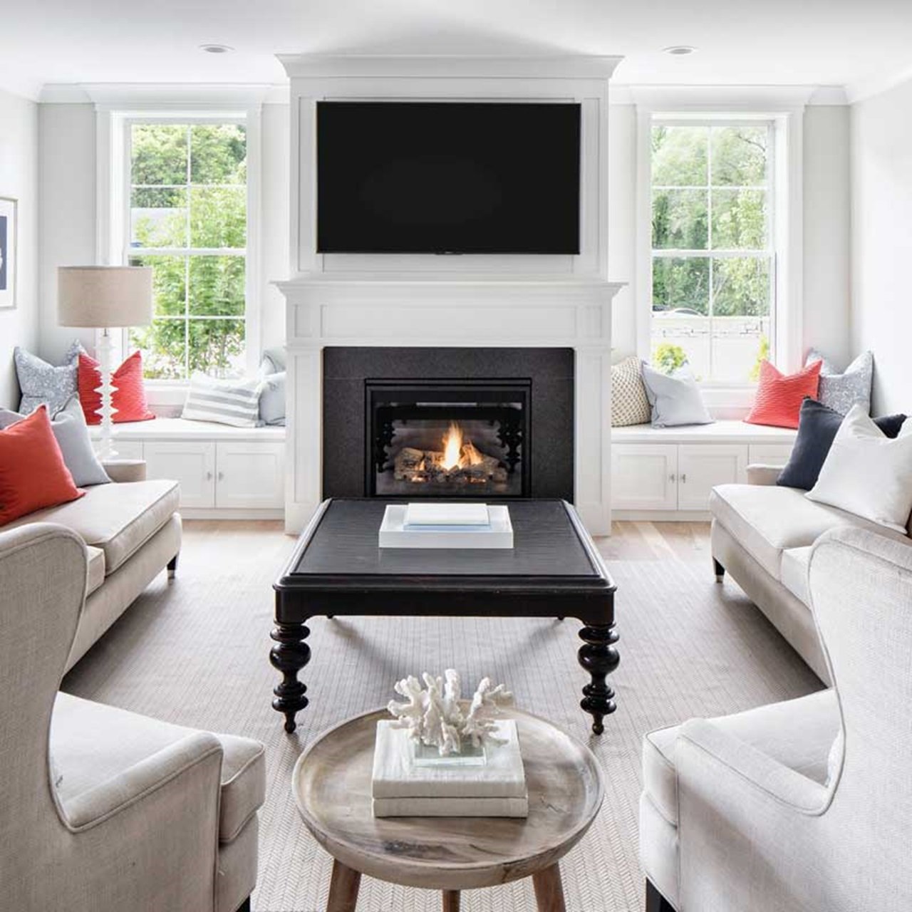 Living room with black fireplace with white single hung windows on either side