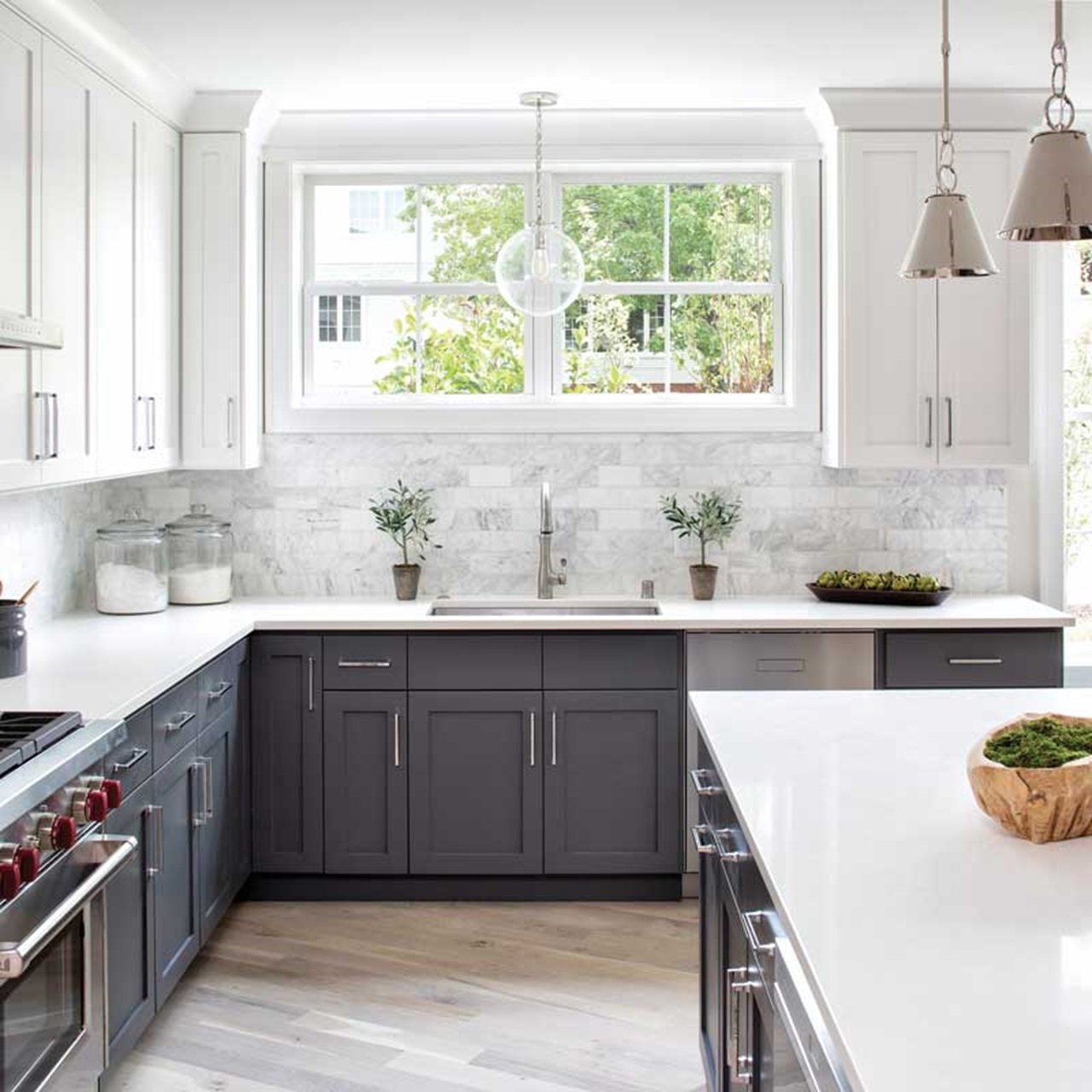 Kitchen with white upper cabinets, grey lower cabinets and two white single hung windows