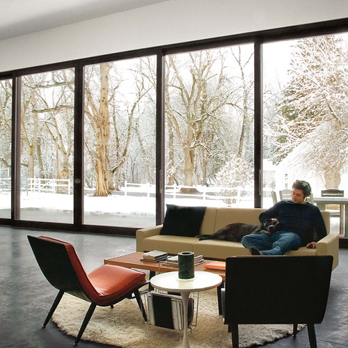 Man In Living Room With Snowy Scene Outside Through Signature Ultimate Lift And Slide Door 