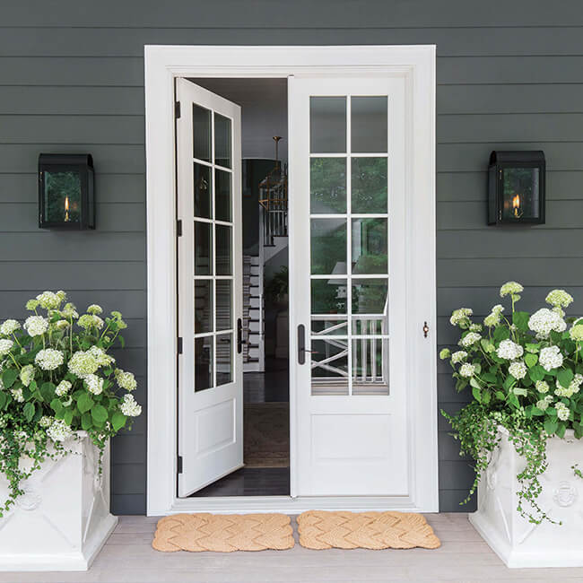 Exterior View Of House Entrance With An Open Signature Ultimate Swinging French Door