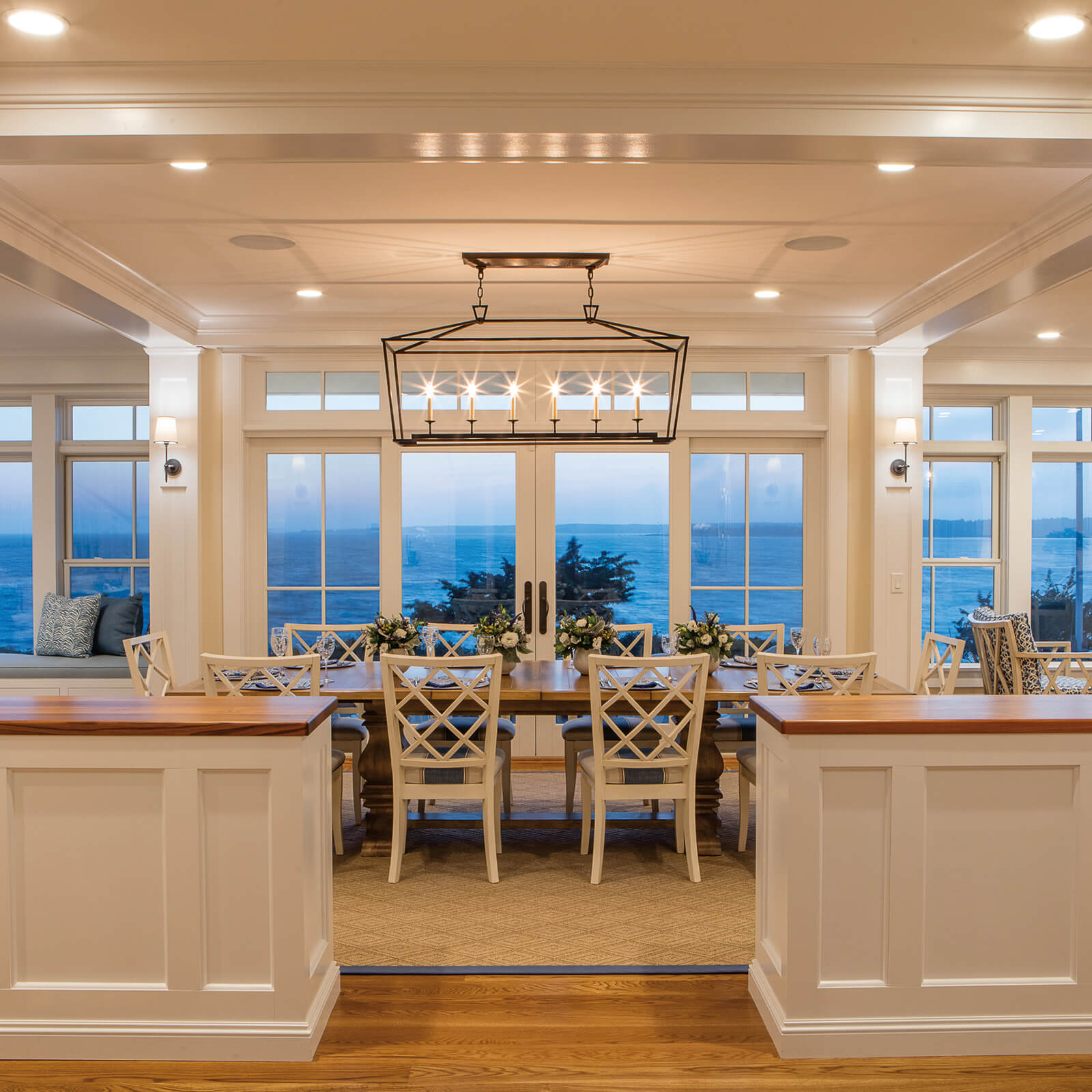Kitchen and Dinning room with tray ceiling with a waterfront view through Marvin Elevate Sliding French Door and Double Hung Windows