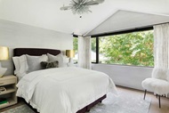 Bedroom with a large modern window with a view of a tree