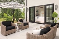 A patio with 4 chairs and an umbrella featuring a Signature Ultimate Sliding French Door g2