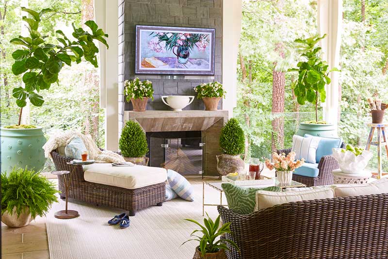 The porch of the House Beautiful Whole Home 2018 in Atlanta, Georgia, filled with greenery and wicker furniture.