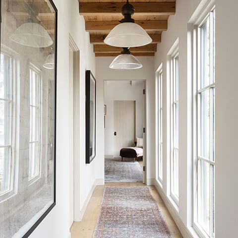 A hallway lined with Marvin windows in Amber Lewis’s renovated Calabasas, California home.