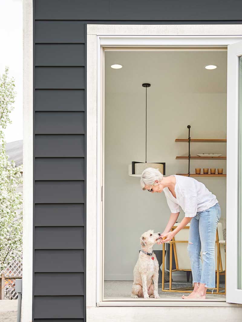 Woman and dog inside guest house, featuring Marvin Ultimate Bi-Fold Door