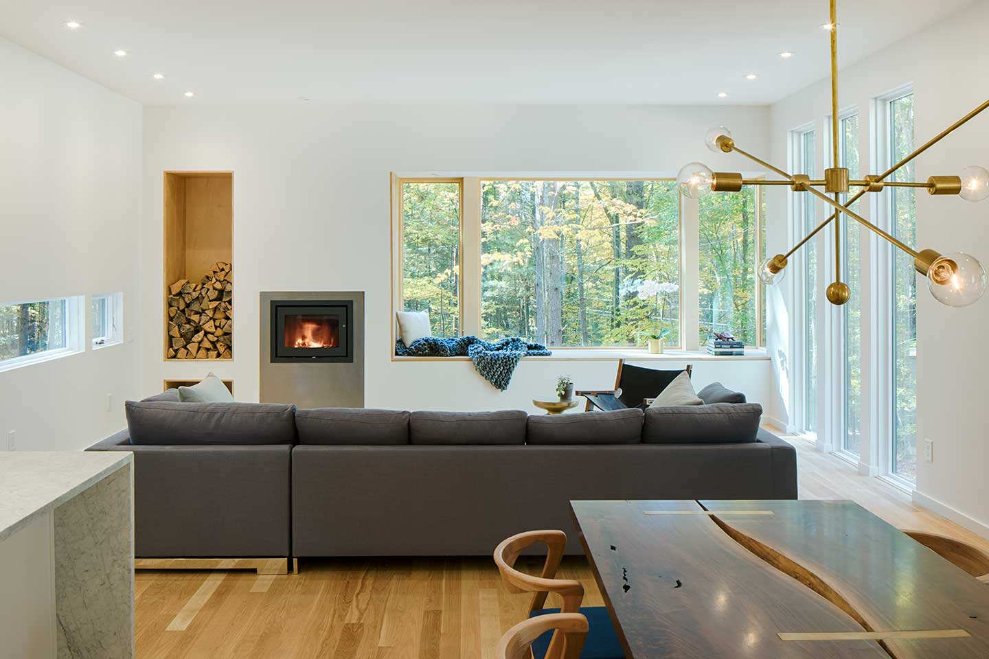 A contemporary living room featuring a window nook beneath a Marvin Ultimate Corner window.