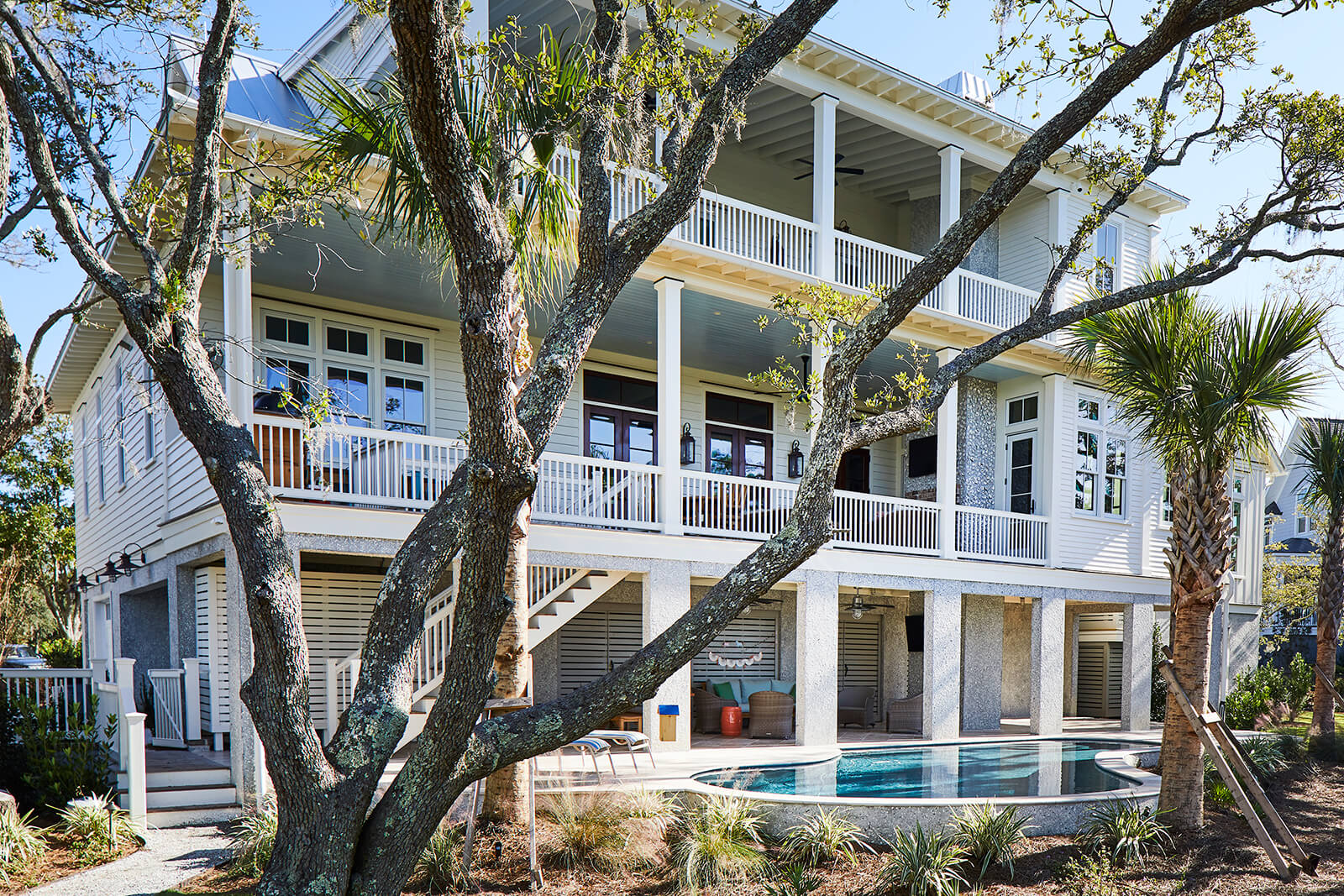 Exterior of Daniel’s Island home in Charleston, South Carolina featuring a pool and two porches on the back of the home.
