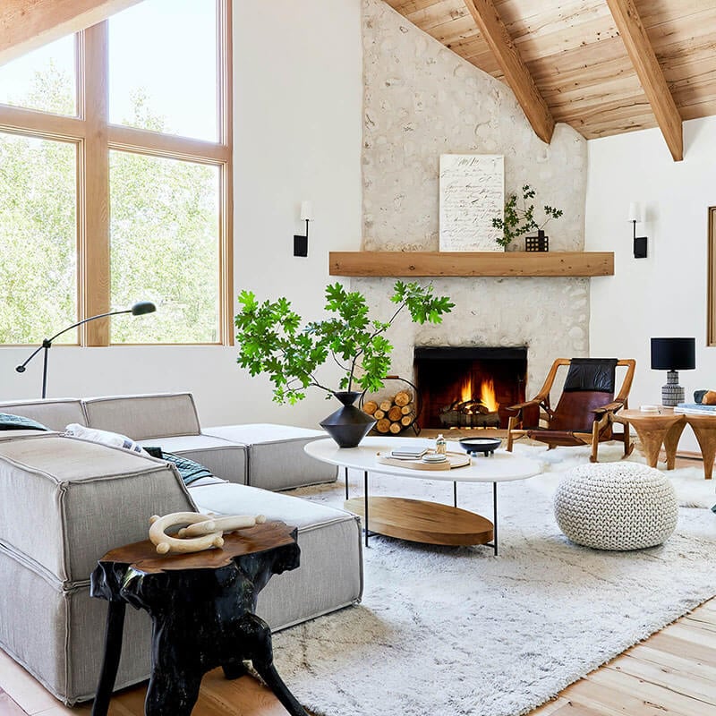 Mountain house living room with plaster fireplace and Marvin narrow frame picture windows