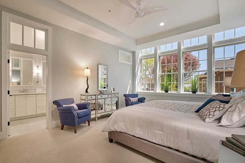 A contemporary bedroom in a historic school turned luxury condos, featuring Marvin Elevate double hung windows.