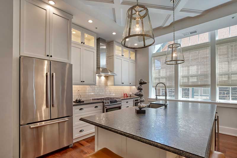A contemporary kitchen in a historic school turned luxury condos, featuring Marvin Elevate double hung windows.