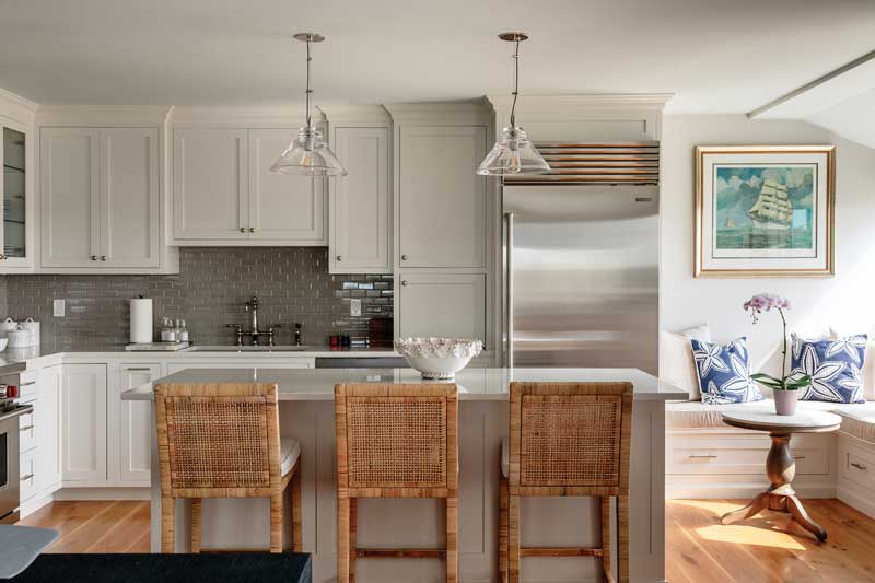 A bright, white kitchen with a light-filled dining nook in a condo at The Standard in Mystic, Connecticut.