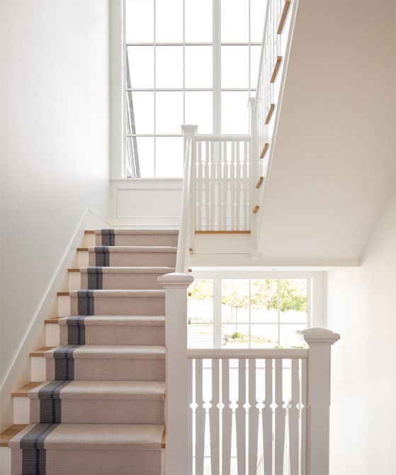 A staircase inside a Swedish traditional home in Medina, Minnesota, featuring Marvin Ultimate windows.