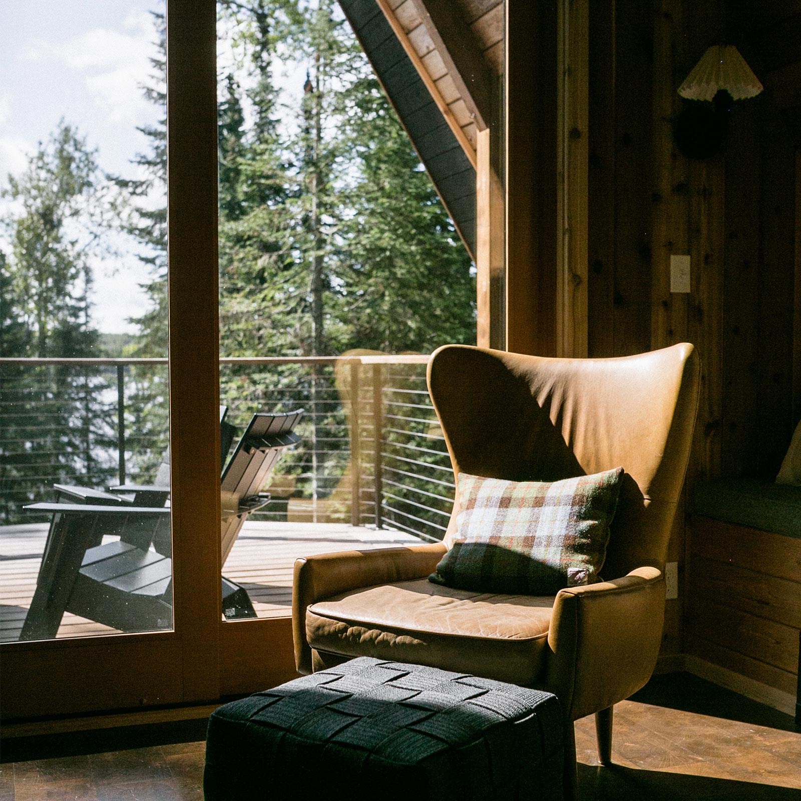 A sitting area overlooking Devil Track Lake of Melissa Coleman’s The Minne Stuga Northwoods cabin, featuring a Marvin Ultimate Sliding French Door. 