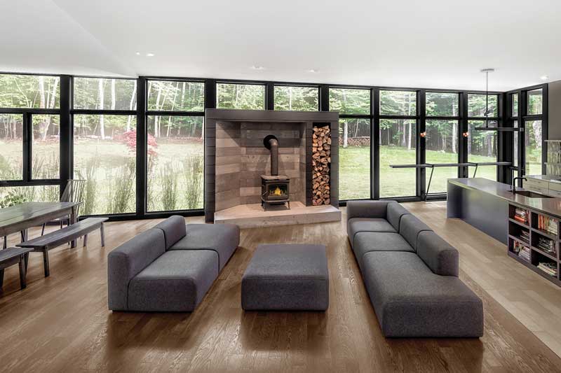 A contemporary living room featuring floor to ceiling Marvin Elevate windows.