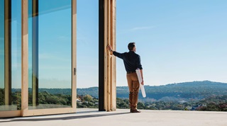 Architect Standing In Framed Building Looking At View