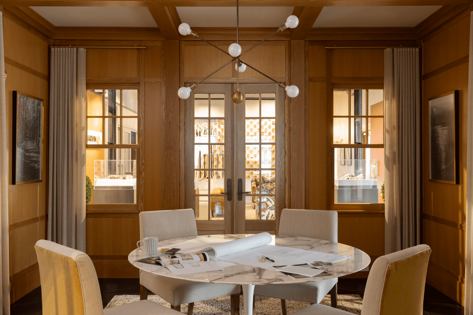 A table and chairs in a room with Marvin windows and doors.