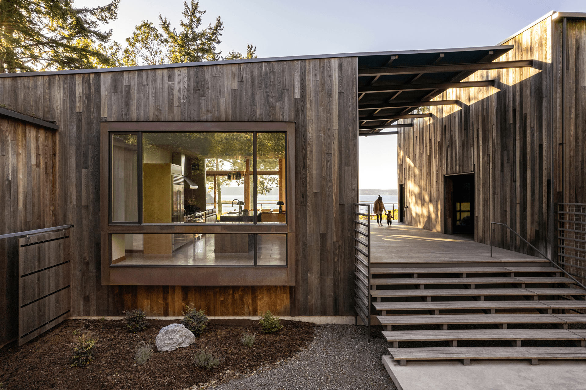 The outside of a rustic home on the water with Marvin Ultimate windows.
