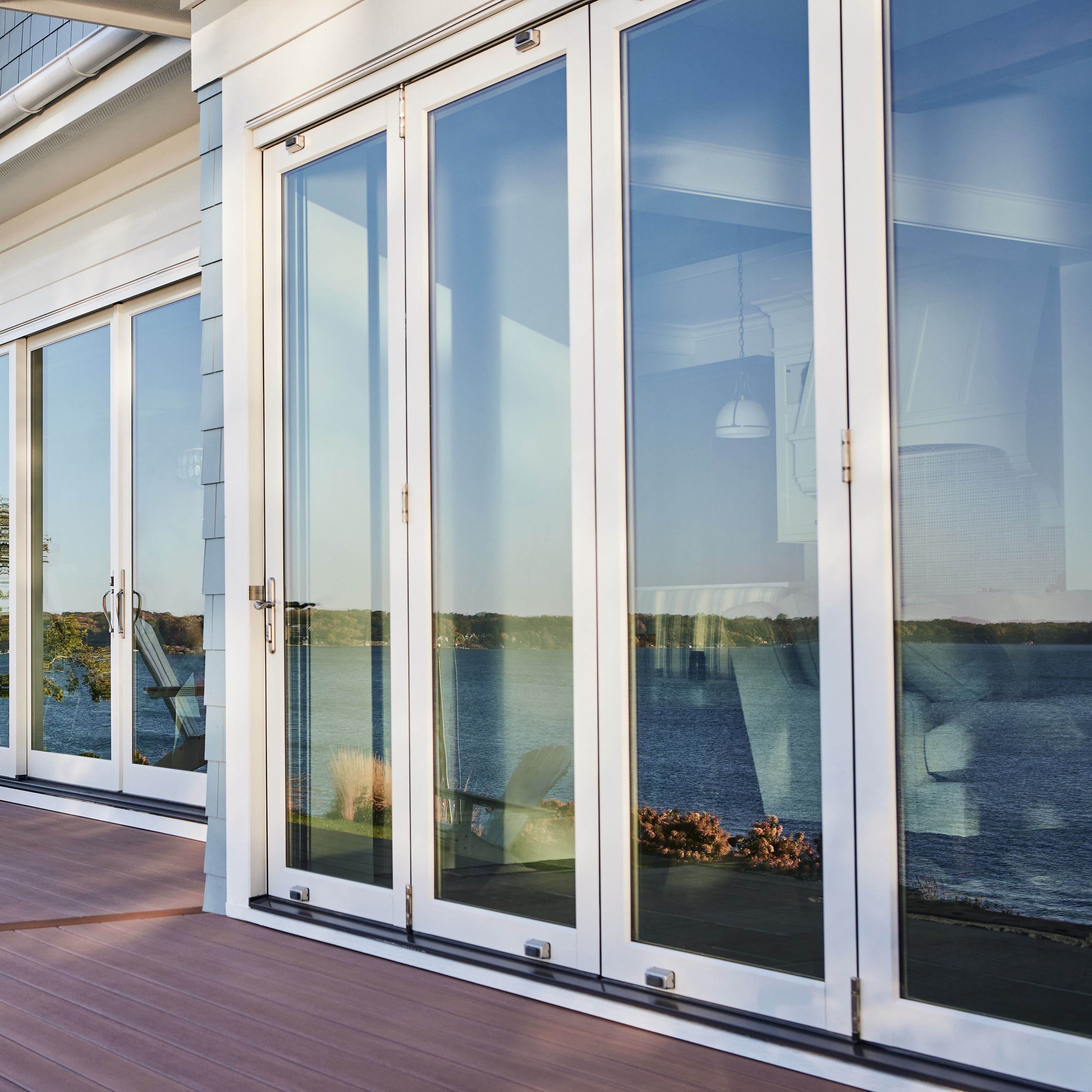 Exterior view from a deck of a closed white Marvin Elevate Bi-Fold Door.